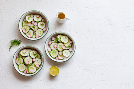 radish and cucumber salad served in a three small round bowls, top view, copy spaceの写真素材