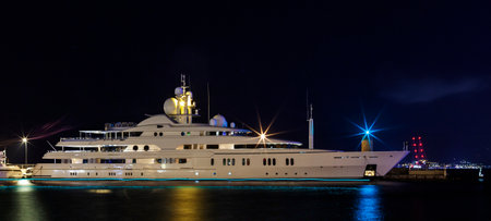 white yacht illuminated by night lights of a portの写真素材