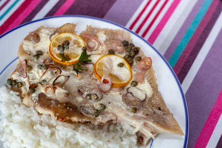 Ray fish wings prepared with capers, shallot and lemons and served with riceの写真素材