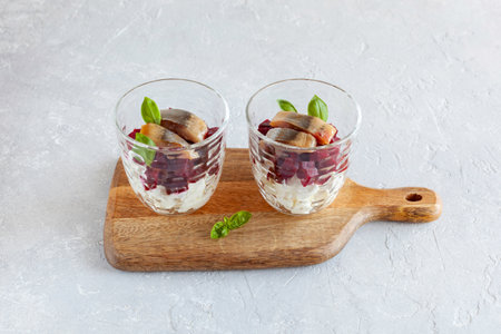 smoked salmon, beetroot and soft cheese salad served in two glasses and decorated with basil leavesの写真素材