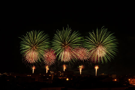 Green and yellow fireworks in a night skyの写真素材