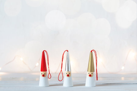 Three Santa Clauses on white background with garland lightsの写真素材