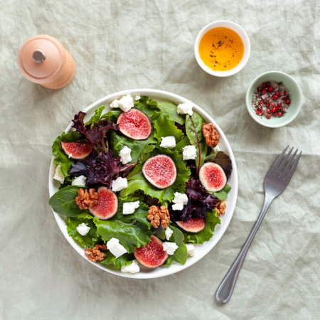 portion of fig, green salad leaves, feta cheese and walnuts salad, top viewの写真素材