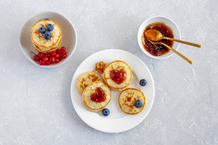 Mini pancakes decorated with heart shape jam and fresh berriesの写真素材