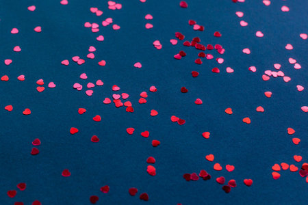 Red heart shape confetti on the dark blue background