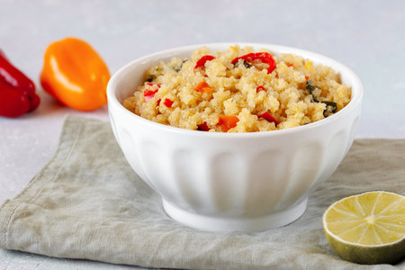 Bowl of quinoa cooked with red and yellow bell pepper and spinachの写真素材
