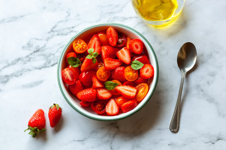 Portion of strawberry, tomato cherry and basil leaves saladの写真素材