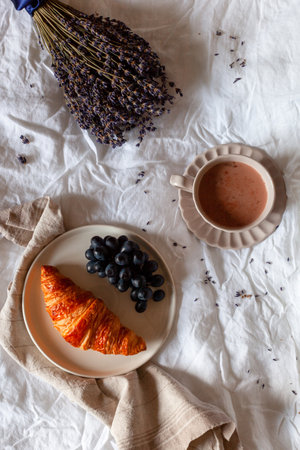Breakfast of croissant, grapes and hot chocolateの写真素材