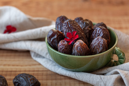 bowl of dates fruits on a wooden table, side viewの写真素材