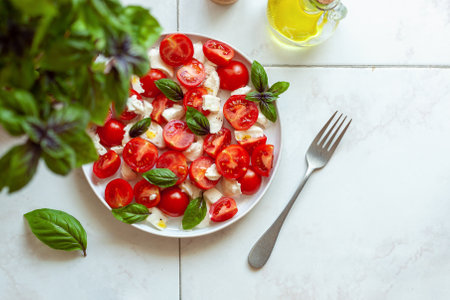portion of caprese salad under the basil plant, top view, copyspace, selective focusの写真素材