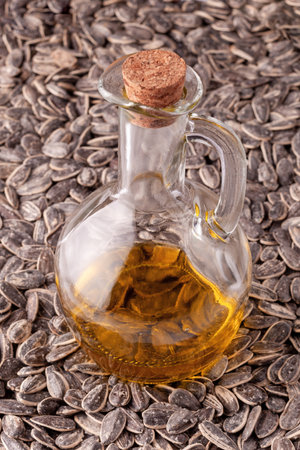 glass pitcher of sunflower oil on the sunflower seeds, side viewの写真素材