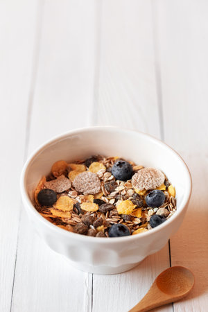 Breakfast bowl of oat flakes on the white wooden table, copyspaceの写真素材