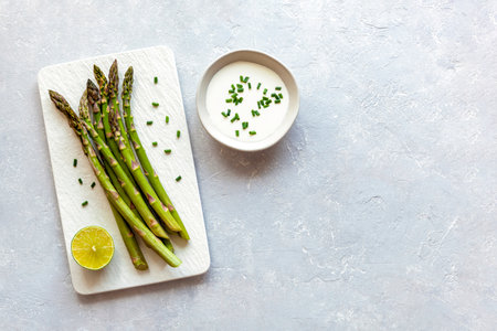 Asparagus stems on the rectangular plate served with green lemon and parsleyの写真素材