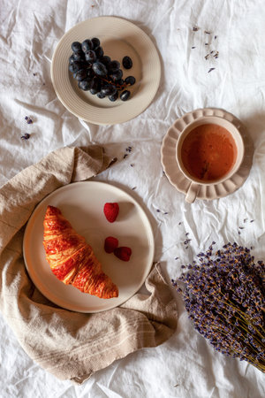 Traditional french breakfast of a croissant, grapes and hot chocolate, top viewの写真素材