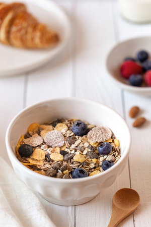 Breakfast bowl of oat flakes with berries, yoghurt and croissantの写真素材