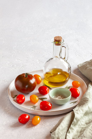 Round tray with different tomato varieties, salt and olive oilの写真素材