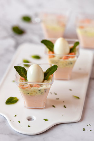 mini portions of salmon and cream mousse decorated with mint leaves, chick imitation, Easter appetizerの写真素材