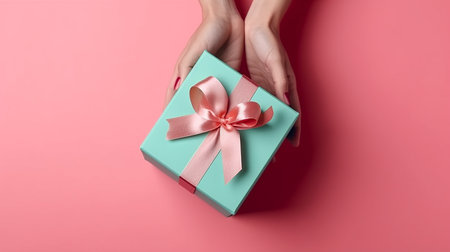 Woman hands holding mint green gift box on the pink background, Generative AIの素材