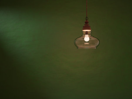 Vintage light bulb hanging on a green wall with copy space.の写真素材