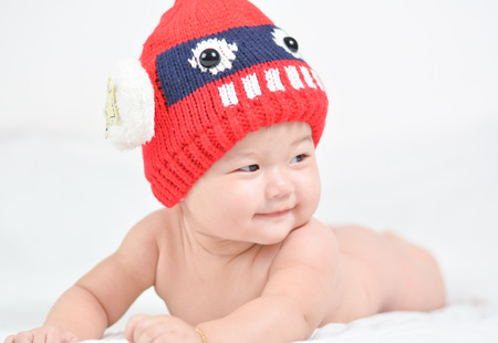 Baby wearing a red hat on a white background