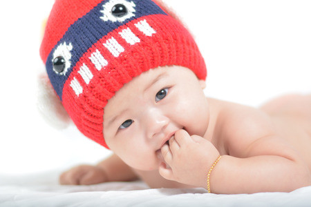 Baby wearing a red hat on a white backgroundの写真素材