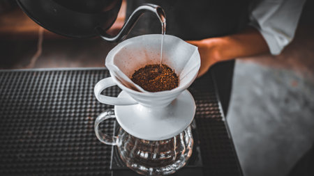 Hand Drip Coffee, Barista pouring hot water on roasted coffee ground with filter,and man is pouring...