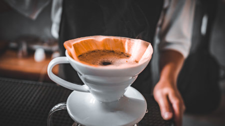 Hand Drip Coffee, Barista pouring hot water on roasted coffee ground with filter,and man is pouring...