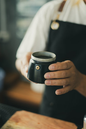 Baristas prepare hot coffee beans in cup pot. to make coffee for steam. Coffee shop concept. in cafe...