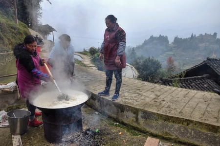 GUIZHOU PROVINCE, CHINA  CIRCA DECEMBER 2017: Three women cook a rice on the occasion of wedding feast hold  outside, high in the mountains of Guizhou province.のeditorial素材