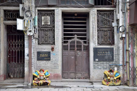 A historical building of Guangzhou with its traditional old-fashioned sliding wooden poles door and...