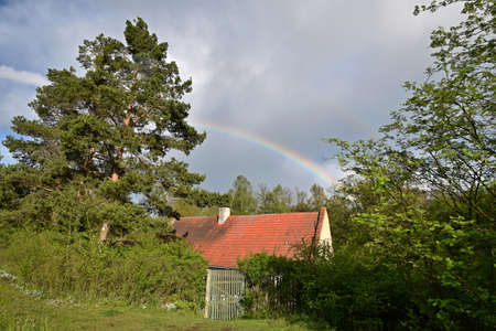 A rainbow above on old village houseの写真素材