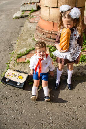 children in school uniforms eat near the schoolの写真素材