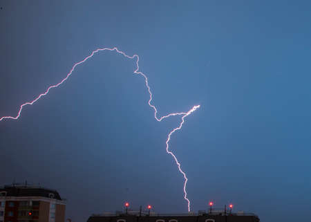 lightning in the night sky over housesの写真素材