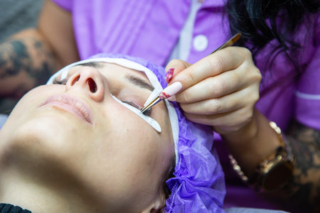 woman at spa salon applying false eyelashes
