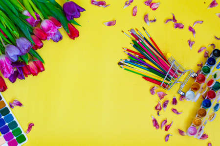 Creative layout with aquarelle palette, paint brushes on yellow backgroundの写真素材