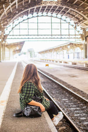 A woman at a retro train stationの写真素材