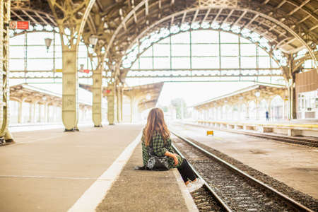 A woman at a retro train stationの写真素材