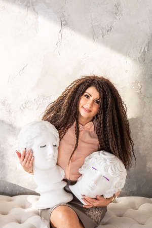 The girl looks at the head of the statueの写真素材