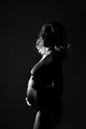 Young beautiful pregnant woman standing on pink backgroundの写真素材