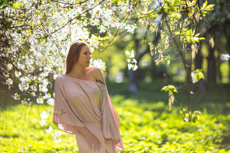 Beautiful young lady in the garden of cherry blossomsの写真素材