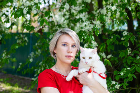Caucasian girl walking in the Park the cats on the harness