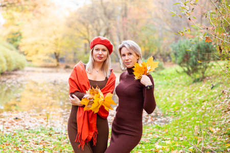 happy smiling womans holding in her hands yellow maple leavesの写真素材