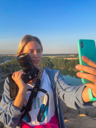tourist girl hold in hands take photography click on modern photo cameraの写真素材