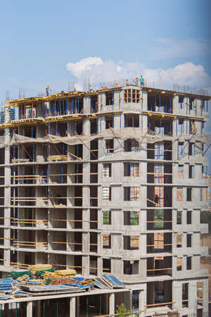 Crane and building under construction against blue sky