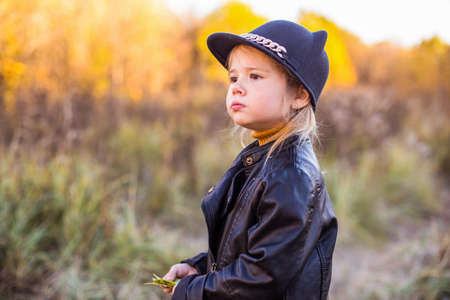 Happy little child, baby girl laughing and playing in autumnの写真素材