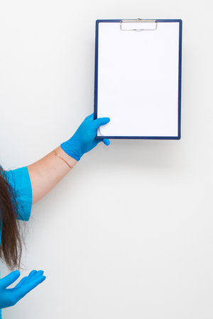 A woman points with a finger at a tablet for paper in her handsの写真素材