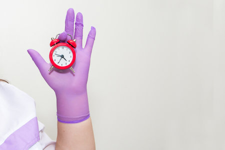 Cropped view of woman holding alarm clockの写真素材