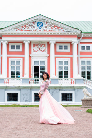 beautiful elegant brunette woman in pink dressの写真素材