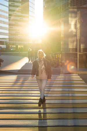stylish woman crossing road on zebra while walking outdoors