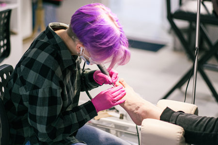 Chiropody master processes nails of female client in the beauty salonの写真素材